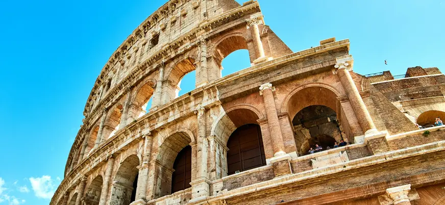 Coliseo de Roma en Italia visto en plano picado bajo un cielo azul despejado
