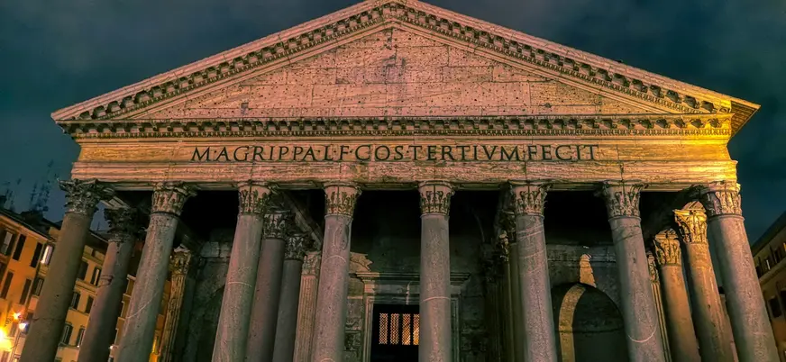 Panteón de Roma iluminado de noche con su fachada clásica y columnas frontales