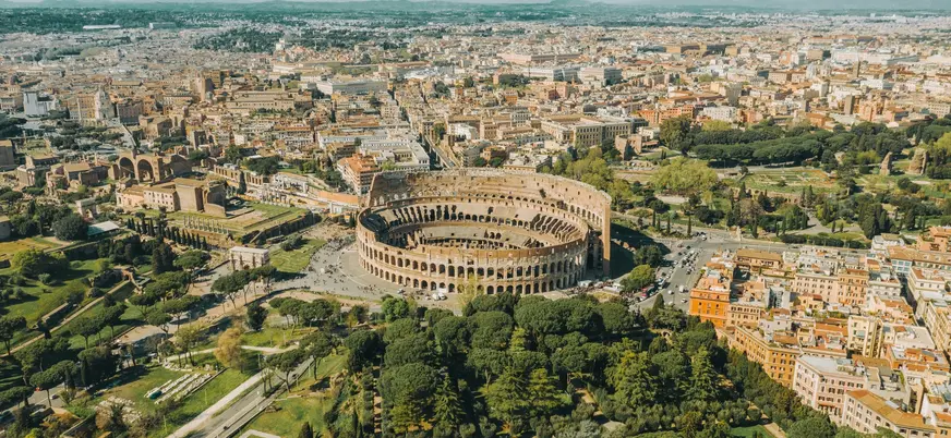 Vista aérea del Coliseo de Roma y su entorno urbano en un día soleado