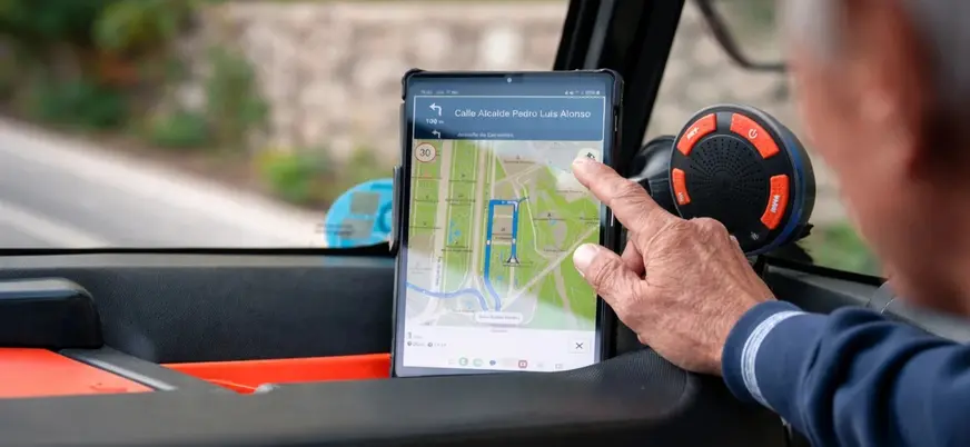 Turista consultando la ruta digital en una tablet dentro del coche en Málaga.