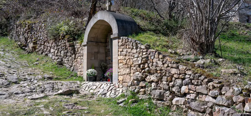 Pequeña capilla o altar de piedra en San Sebastián de Garabandal, Cantabria, situada junto al camino empedrado