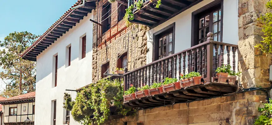 Balcón tradicional con flores en una casona de Santillana del Mar, Cantabria.