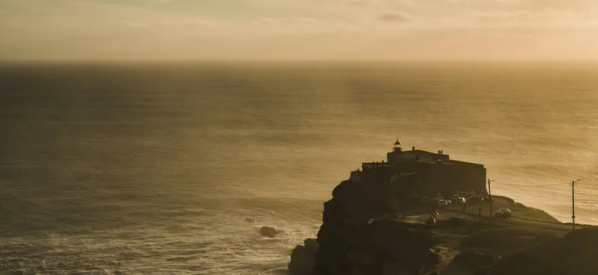 Fuerte de San Miguel Arcángel sobre el acantilado de Nazaré frente al mar brumoso.