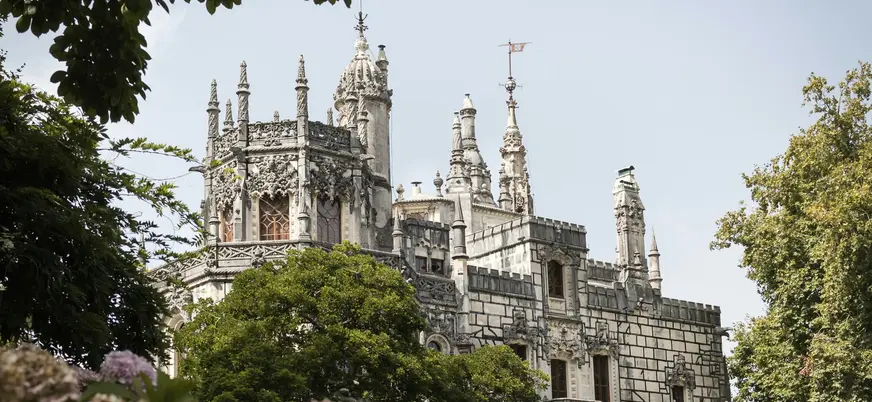 Fachada de la Quinta da Regaleira entre hortensias en Sintra, Portugal.