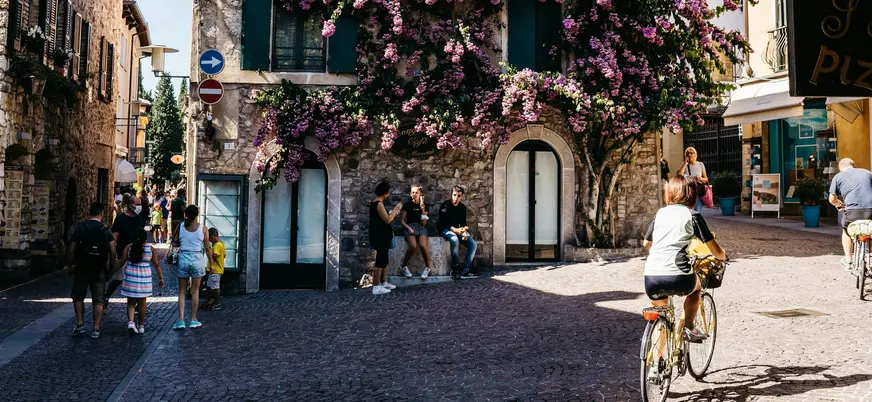Calle peatonal con fachadas floridas en el centro histórico de Sirmione, Italia