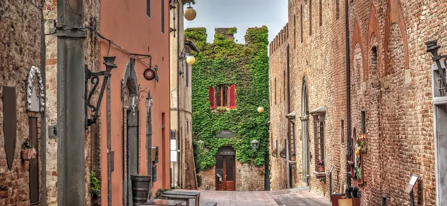 Calle medieval con casas de piedra y hiedra en la Toscana, Italia