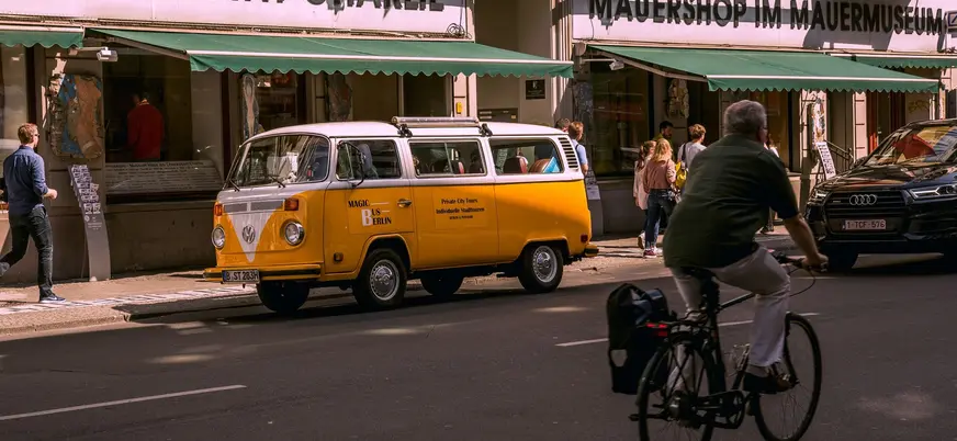 Furgoneta Volkswagen amarilla frente al Museo de Checkpoint Charlie en Berlín.