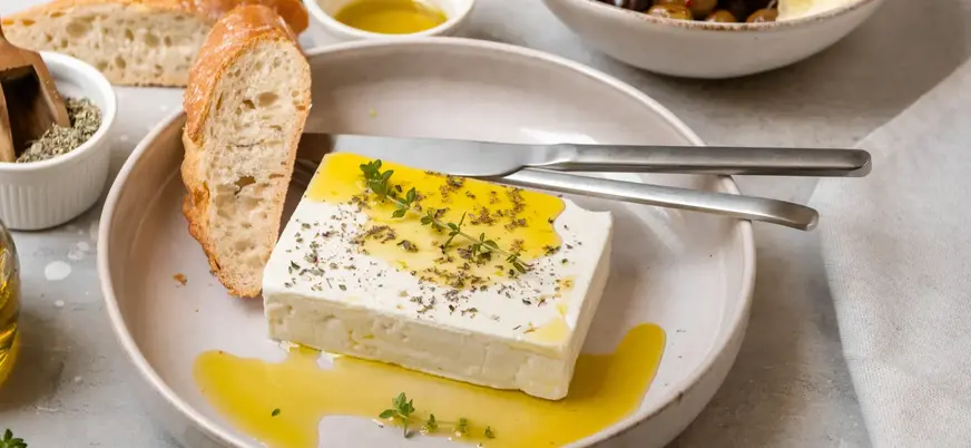 Bloque de queso feta con aceite de oliva, orégano y pan artesano en Atenas