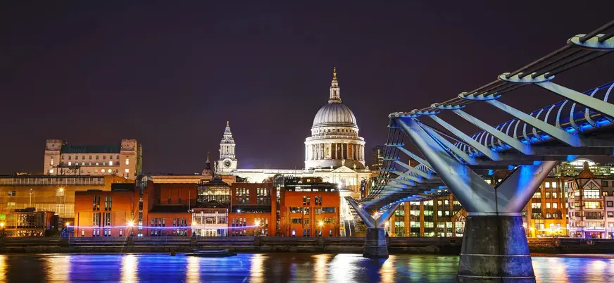 Catedral de San Pablo y Millennium Bridge iluminados de noche en Londres.