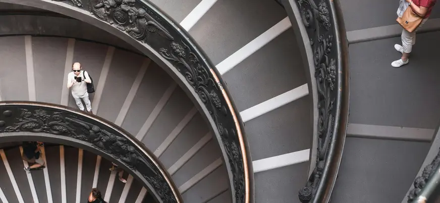 Turistas bajando por la escalera de caracol de los Museos Vaticanos