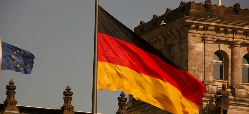 Bandera de Alemania y de la Unión Europea frente al edificio del Reichstag.