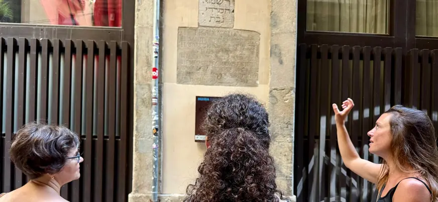 Guía turística explicando inscripción hebrea, Call de Barcelona