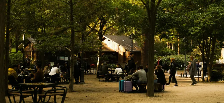Personas jugando al ajedrez en una zona arbolada del Retiro, Madrid.