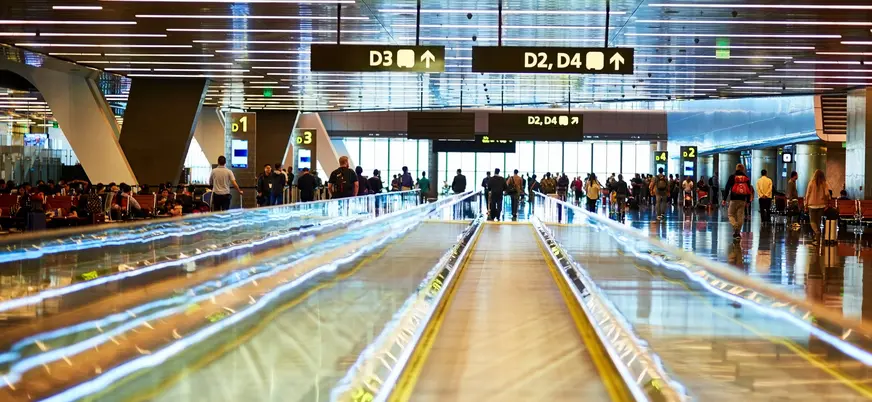 Pasajeros en pasarela mecánica del Aeropuerto de Asturias