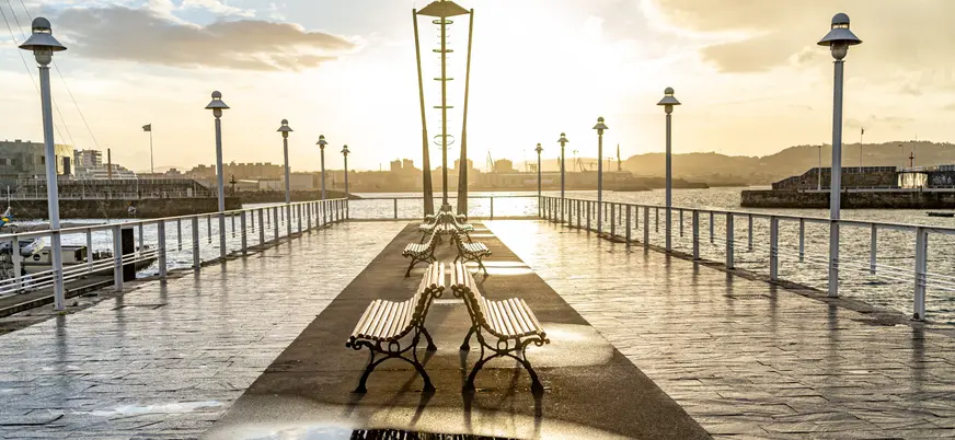 Paseo marítimo de Gijón al atardecer, con farolas y vistas al mar Cantábrico, Asturias, España
