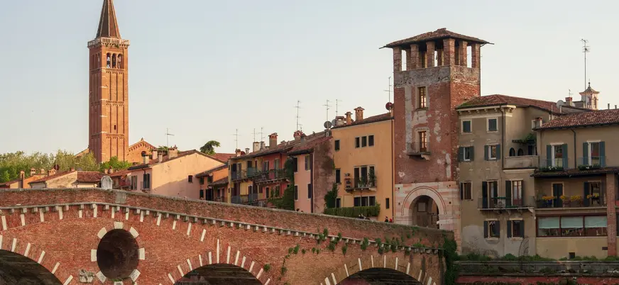 Puente Castelvecchio y casas históricas junto al río Adigio en Verona, Italia