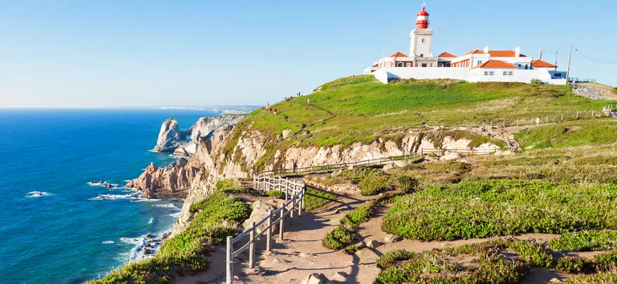 Acantilados del Cabo da Roca con su faro sobre el océano en un día despejado.