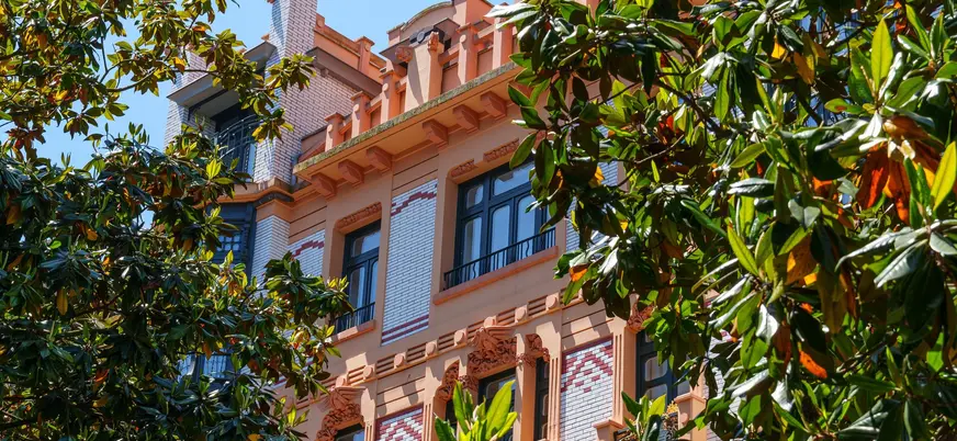 Edificio modernista entre árboles en el centro de Gijón