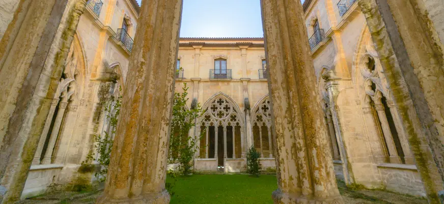 Claustro histórico con jardín interior durante visita guiada en Oviedo