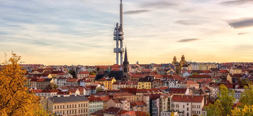 Vista panorámica de la Torre de Televisión Žižkov sobre los tejados de Praga al atardecer.