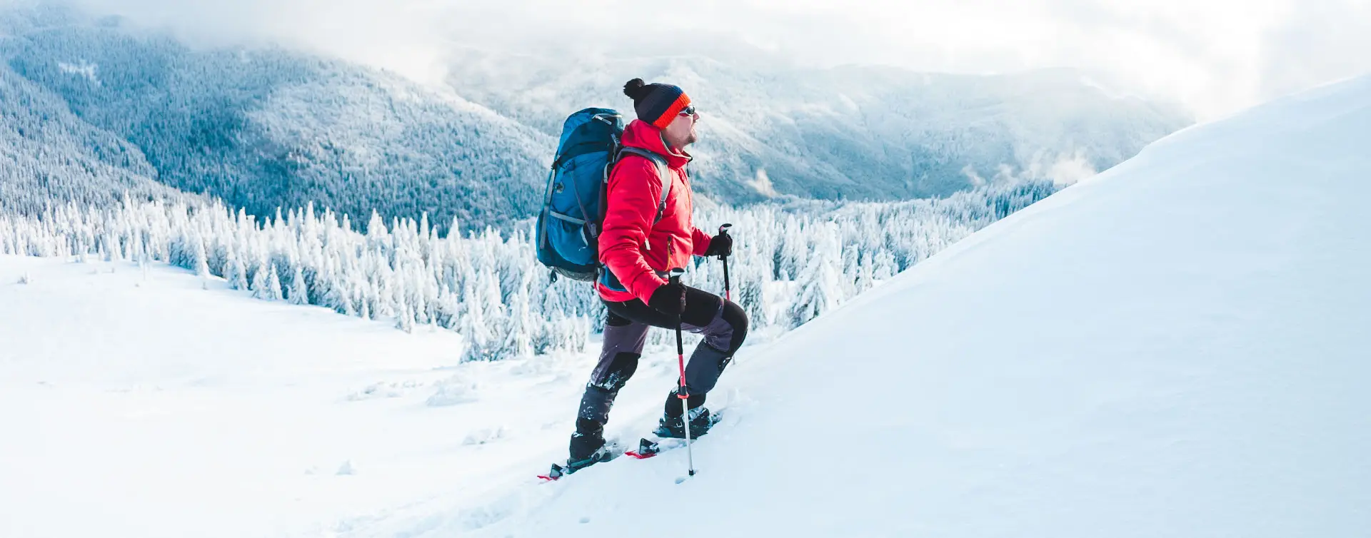 Hombre con chaqueta roja y mochila haciendo una ruta en raquetas de nieve por Sierra Nevada - Ruta en Raquetas de Nieve por Sierra Nevada - Actividades,  Experiencia al aire libre, Ocio y Turismo activo Buendía Andalucía 