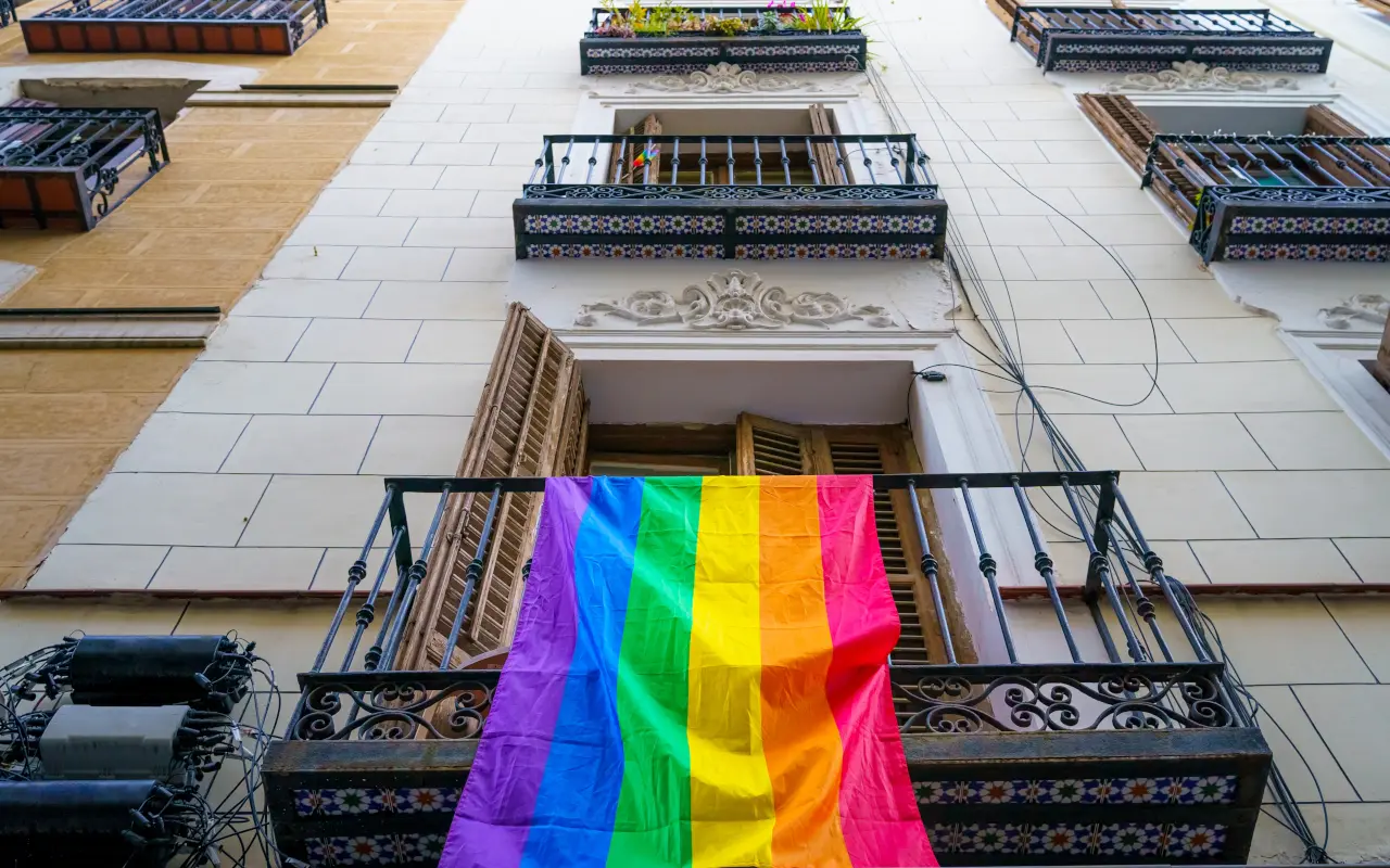 Fachada de un edificio con la bandera que representa los derechos LGTBI.
