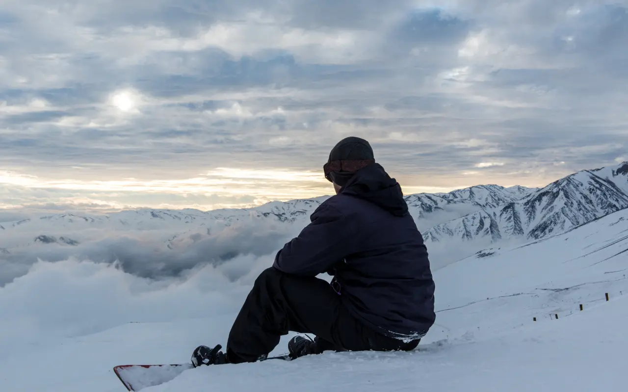 Chico sentando contemplado las vistas de las montañas.