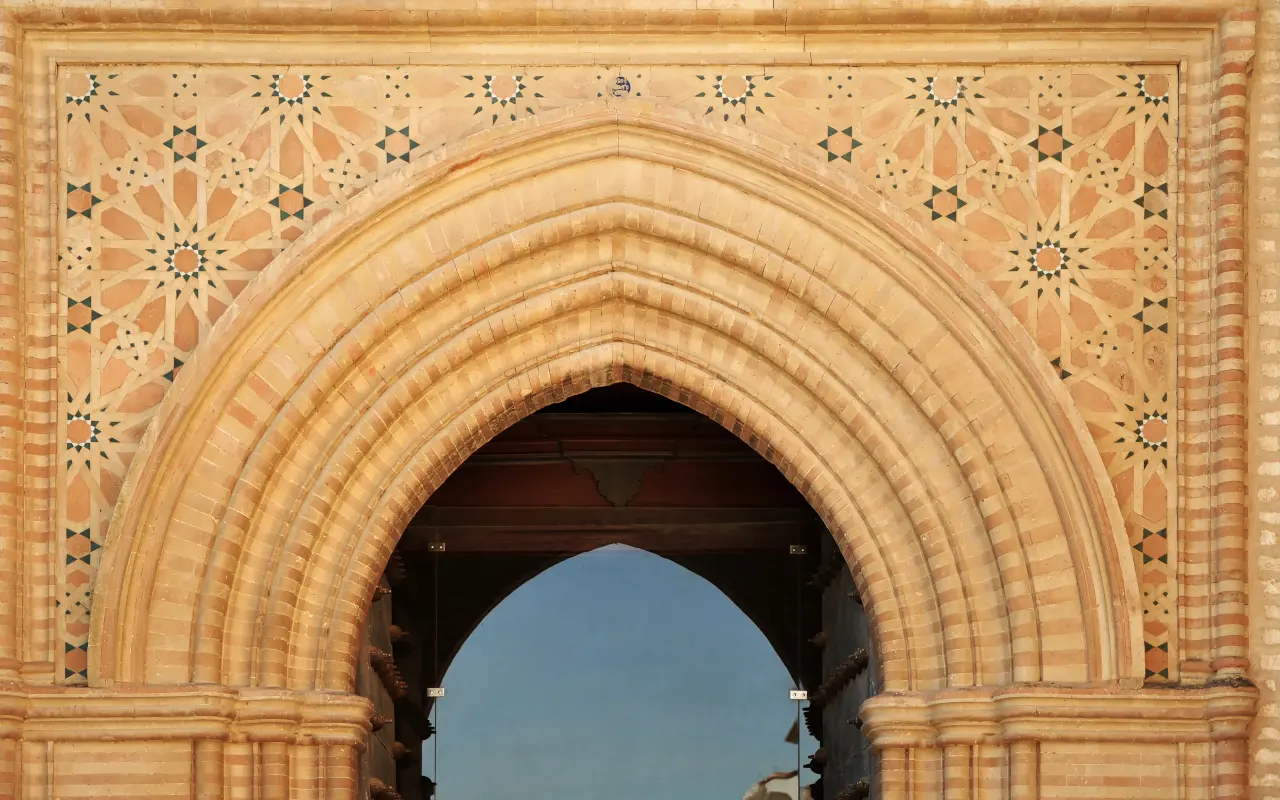 Vista de los elementos de arte mudéjar en el Monasterio de San Isidoro del Campo, con intricados motivos decorativos que combinan influencias cristianas y musulmanas.