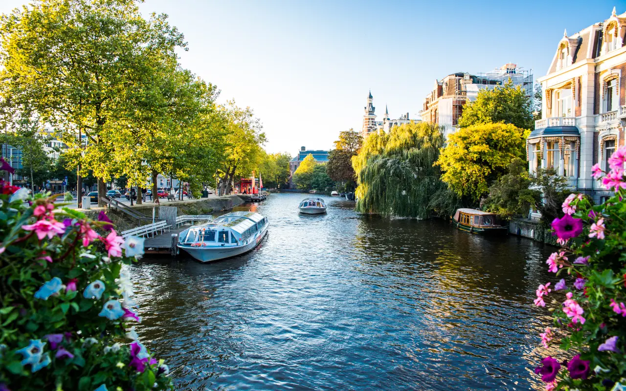 Barcos en los canales de Ámsterdam rodeados de árboles