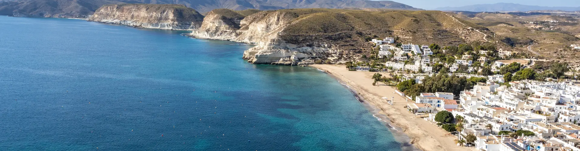 Vista de Cabo de Gata, con sus impresionantes paisajes de acantilados y aguas cristalinas rodeadas de montañas desérticas.