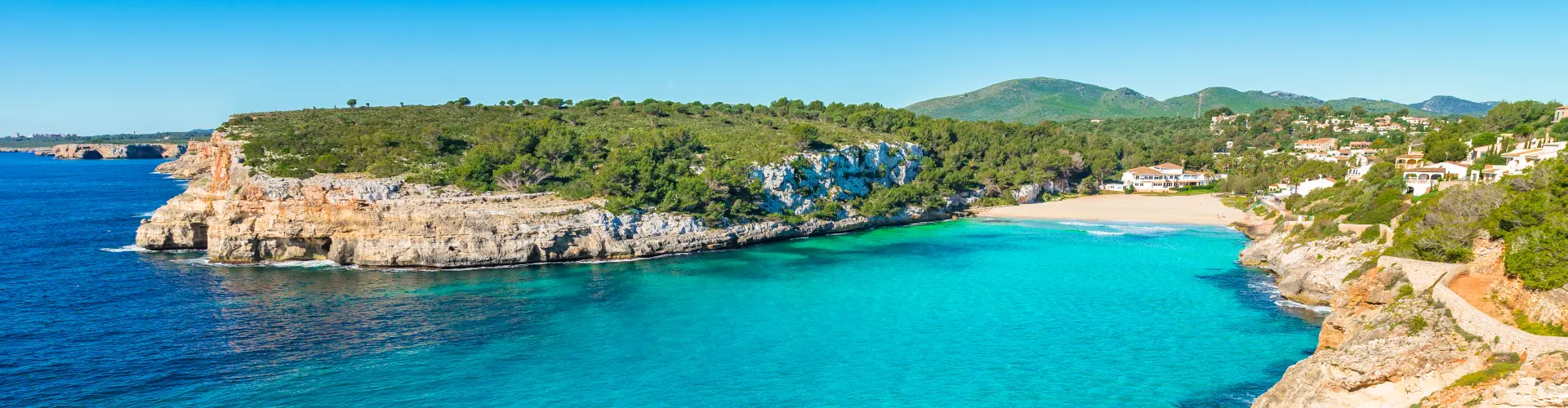 Aguas cristalinas de cala Romántica, perfecta para practicar actividades acuáticas.