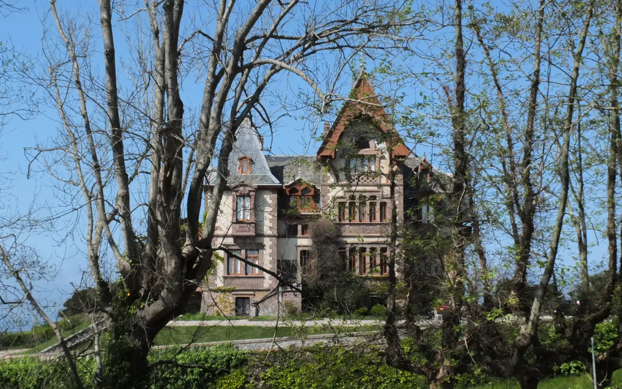 Vista entre árboles de la Casa del Duque de Almodóvar del Río, Comillas