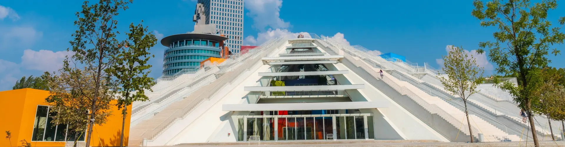 Vista de la Pirámide de Tirana, destacando su estructura inconfundible y su diseño futurista, rodeada de la ciudad.