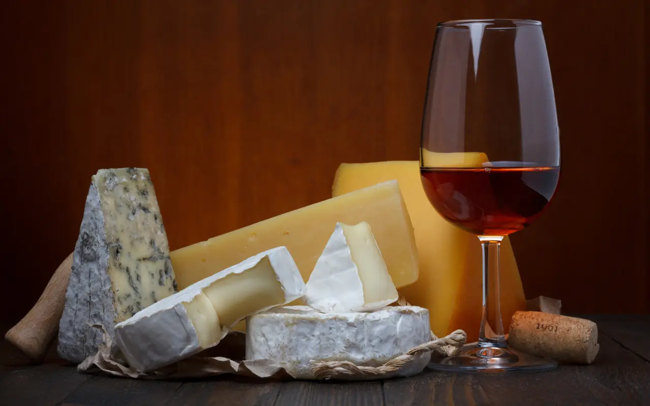 Primer plano de quesos acompañado de vino que harán las delicias de tu paladar.