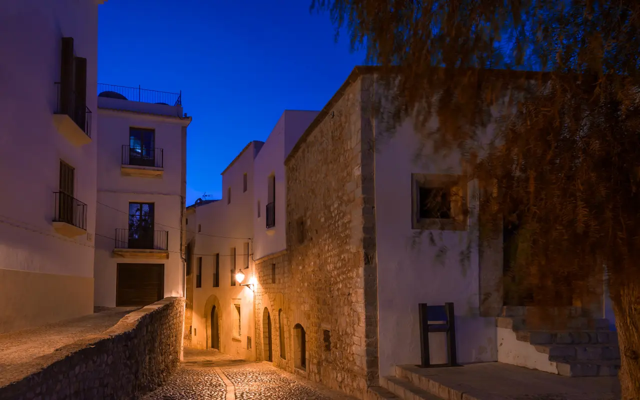 Calles empedradas de Ibiza por la noche, creando un ambiente mágico.