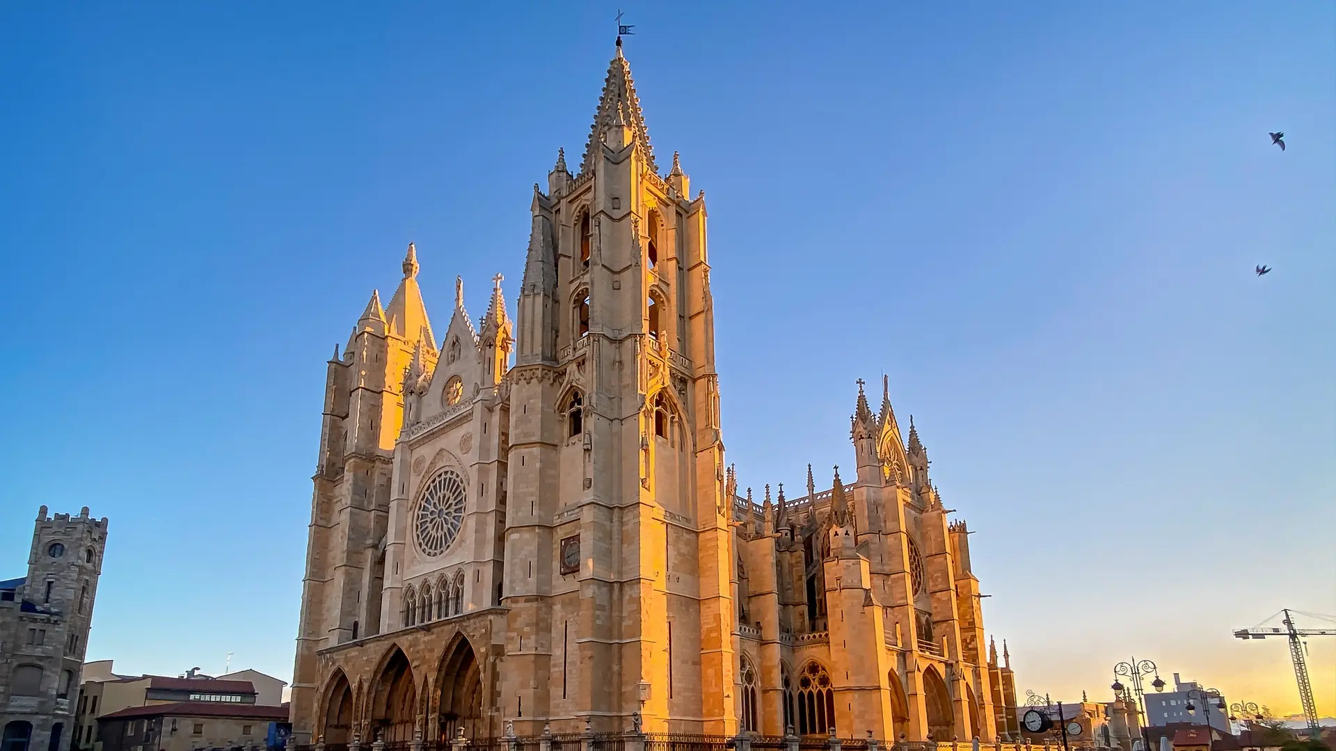 Catedral de León al atardecer, edificio gótico francés conocido como Pulchra Leonina, bajo un cielo azul despejado.