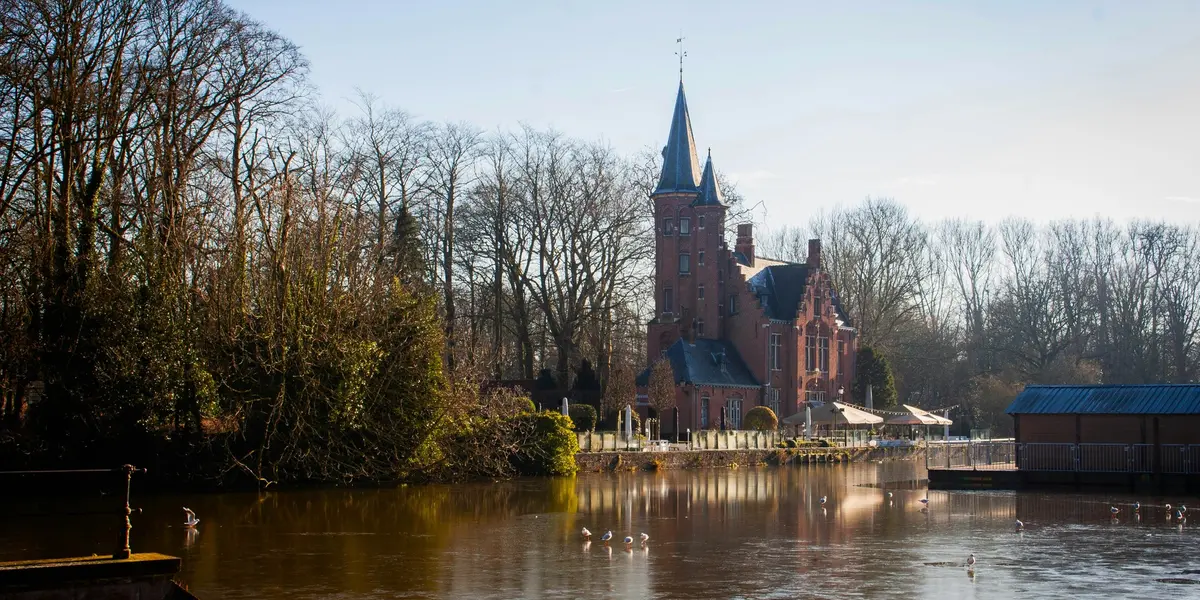 Vista del Lago del Amor en Brujas, Bélgica, con su icónico edificio rojo reflejado en el agua