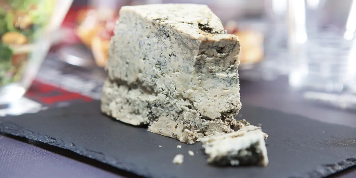 Cuña de Queso de Cabrales, un queso azul típico de Asturias, España, servido sobre una tabla negra.