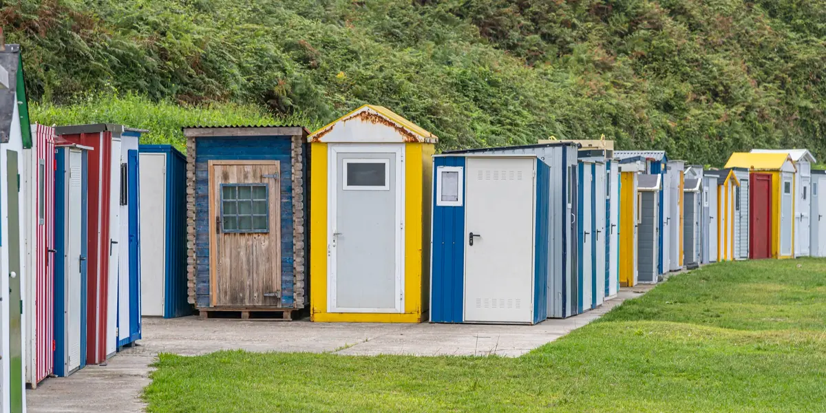 Casetas de colores para pesca alineadas en el puerto de Luarca, Asturias, junto al prado.