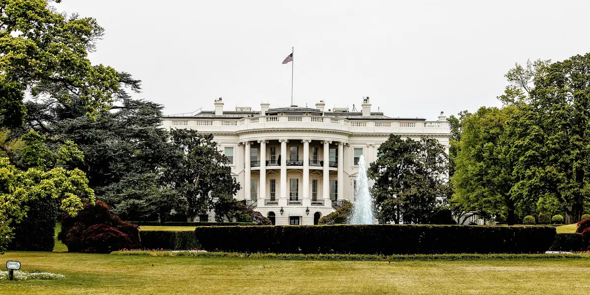 Vista frontal de la Casa Blanca en Washington D.C., con un jardín y una fuente en primer plano.