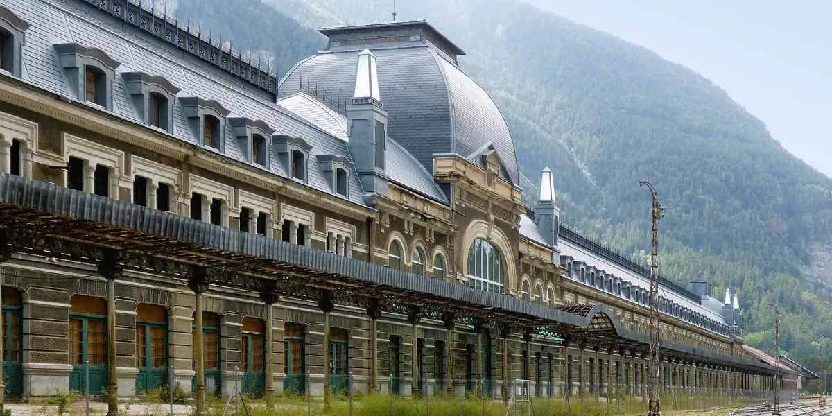  Fachada principal de la Estación Internacional de Canfranc con una gran cúpula y el Pirineo al fondo.
