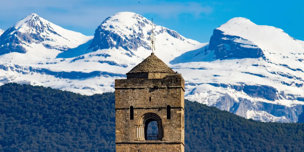 Primer plano de la torre de Aínsa con los Pirineos nevados de fondo en Huesca.