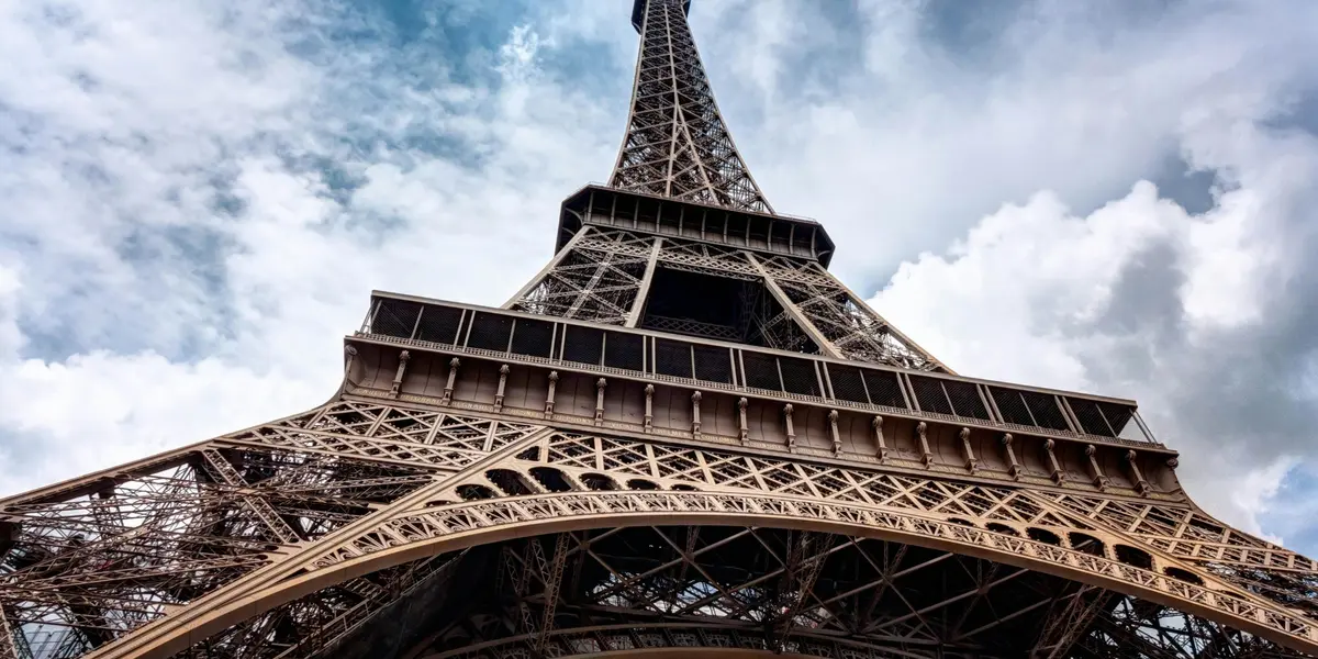 Torre Eiffel vista desde su base hacia el cielo nublado en París, Francia