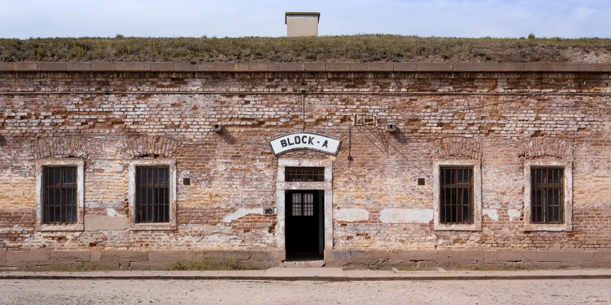 Edificio de ladrillo visto con cartel de Block A en el Memorial de Terezín.