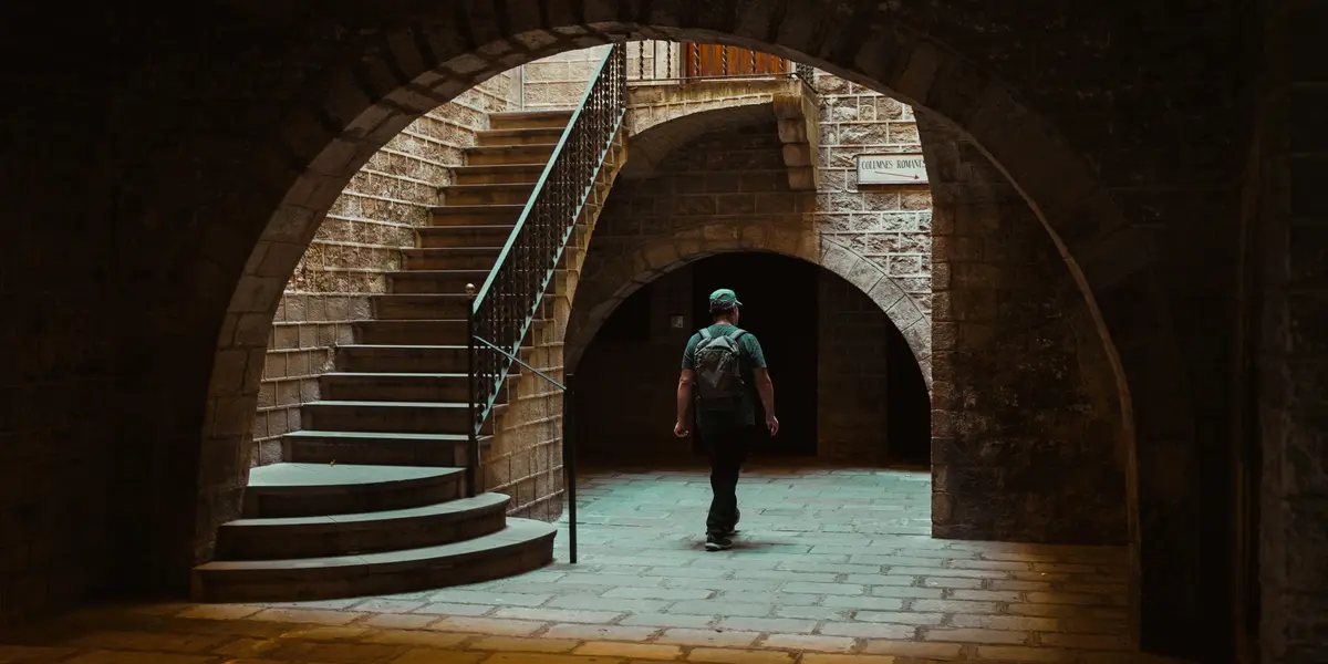 Hombre caminando por patio de piedra en el Barrio Gótico