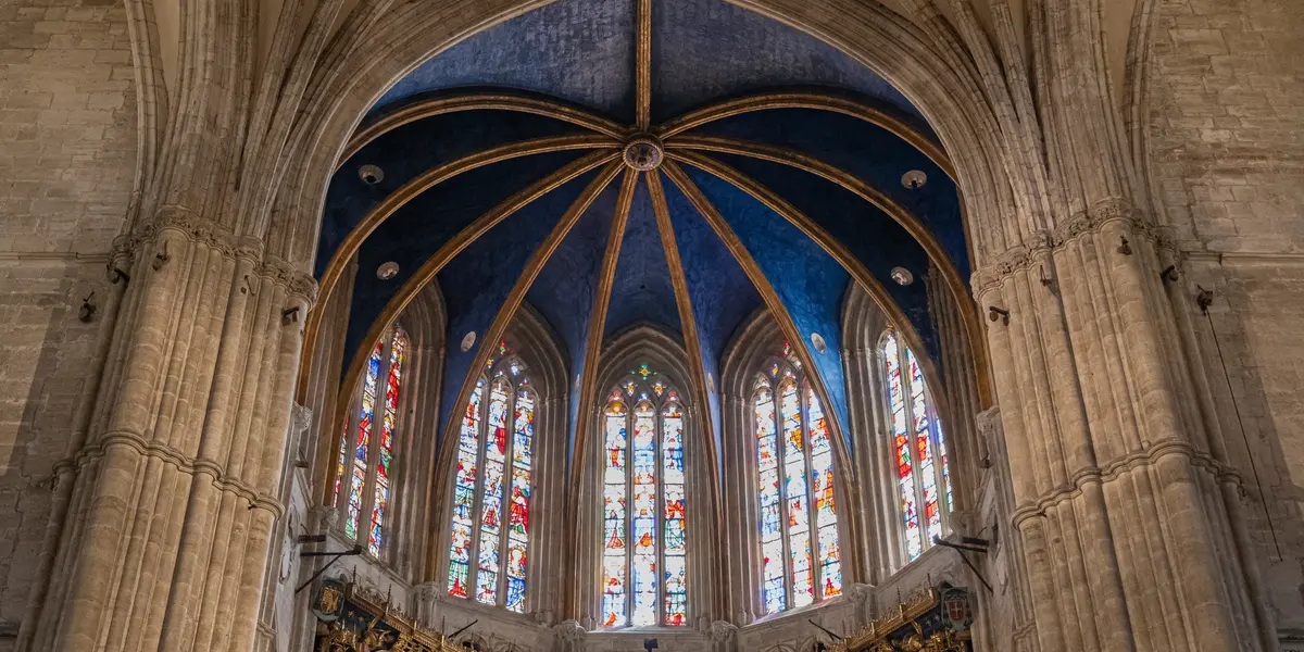 Interior de la Catedral de Oviedo, con su impresionante bóveda azul estrellada y vidrieras góticas llenas de color.