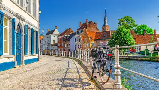 Bicicleta junto al canal y casas en Brujas.