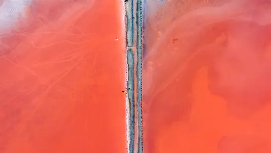 Vista aérea de un camino dividiendo las aguas de la Laguna Rosa de Torrevieja.