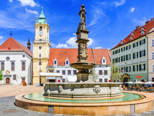 Fuente histórica en una plaza de Bratislava rodeada de edificios antiguos.
