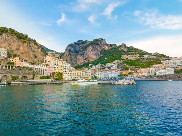 Vista de Capri desde el mar, con los Jardines Augusto, el puerto y una estampa de postal.